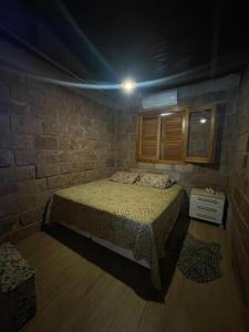 圣玛丽亚Rancho的一间卧室设有一张床和砖墙