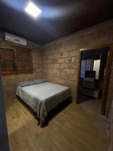 圣玛丽亚Rancho的一间卧室设有一张床和砖墙