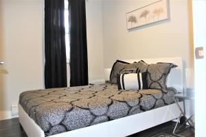 尼亚加拉瀑布Luxury Boutique 2 Bedroom Condo - 1B的一间卧室配有一张带黑白枕头的床