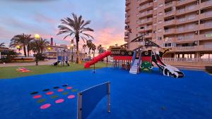 拉曼加戴尔马尔梅纳La Manga - Puerto y Playa - 3 dormitorios的蓝地毯上带滑梯的游乐场