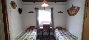 圣路易斯Hospedaje Serrano Suyuque Viejo的配有桌子和窗户的客房内的两张床