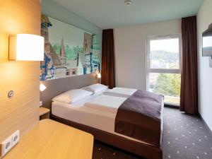 兰河畔马尔堡B&B Hotel Marburg的酒店客房设有床和窗户。