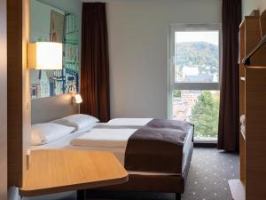 兰河畔马尔堡B&B Hotel Marburg的酒店客房设有床和窗户。