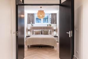 阿姆斯特丹Central Luxury Apartment的一间卧室设有一张床和一个窗口