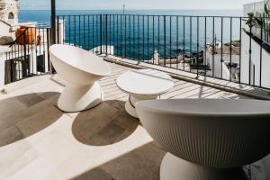 莫诺波利Le Contrade Di San Salvatore的阳台设有3张白色桌子,享有海景。