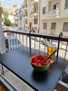 雅典Στούντιο Διπλα στην Ακρόπολη的坐在阳台上桌子上的一碗水果