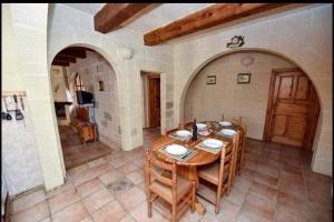 萨奈特Farmhouse with Pool, Tas-Summiena Gozo的一间带木桌和椅子的用餐室