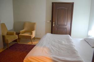 伊斯兰堡Landmark III High Rated Apartment的一间卧室配有一张床、两把椅子和一扇门