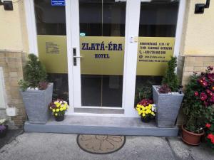 俄斯特拉发ZLATÁ-ÉRA的一座种植盆栽植物的建筑的前门