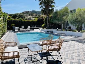 卡尔维Résidence Villa Branda的一个带椅子的庭院和一个游泳池