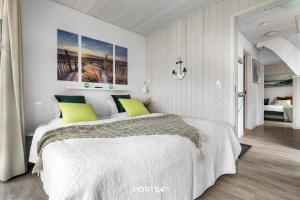温德托尔夫Ferienhaus Möwe 12 Marina Wendtorf的白色卧室配有一张带黄色枕头的大床