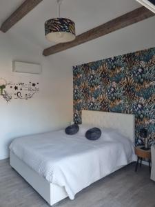 Puyricard阿罗希杜宾酒店的卧室配有白色的床铺和壁画