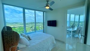 ArraijÃ¡n10G Perfect 2 Bedroom with Ocean and Jungle Views的一间卧室配有一张床,阳台配有桌子
