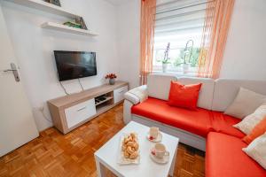 马里博尔Apartma Golob的客厅配有红色沙发和电视