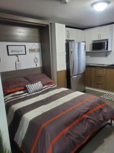 罗贝瓦勒Motel domaine l'Avantage Inn的一间卧室配有床和不锈钢冰箱