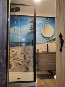 罗贝瓦勒Motel domaine l'Avantage Inn的带淋浴的浴室,享有海滩美景