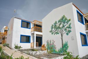 Cidade VelhaEncosta Azul Guesthouse的白色的建筑,上面有一棵树