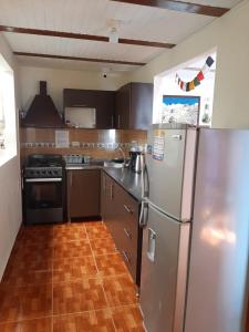 萨兰托Km0 Hostel的厨房配有不锈钢用具,铺有木地板