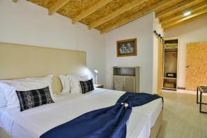Cidade VelhaEncosta Azul Guesthouse的卧室配有带枕头的大型白色床