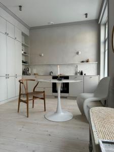 海门林纳Uniikki ja tunnelmallinen empireasunto Hämeenlinnan ydinkeskustassa的白色的厨房配有桌子和椅子