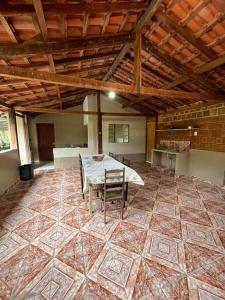 圣若泽-杜巴雷鲁Casa na Roça em São José do Barreiro SP的客房铺有瓷砖地板,配有桌椅。