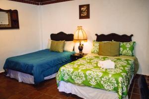 ZitácuaroSolache Inn的一间卧室设有两张床和一张桌子上的台灯。