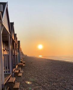 荷尼湾Evening Tide的海滩上的日落与一排房子