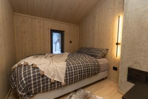 弗洛High standard cabin in a quiet area in the bossom of nature near Flå的卧室配有一张床铺,位于带木墙的房间内