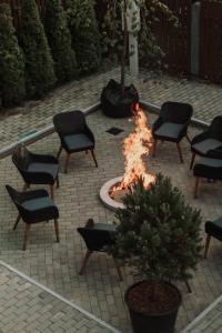 巴蒂泽瓦娜格丽达酒店的庭院里的火坑,庭院里摆放着椅子和一棵树