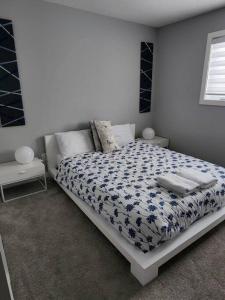 卡尔加里Cozy Gems of Kensington的一间卧室配有一张带蓝色和白色棉被的床