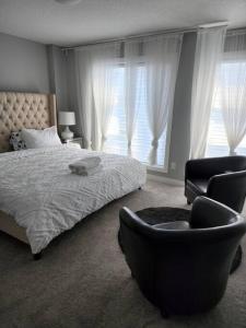 卡尔加里Cozy Gems of Kensington的一间卧室配有一张床、一把椅子和窗户。