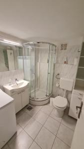 普尔维奇卢卡Apartmani Ela的带淋浴、卫生间和盥洗盆的浴室