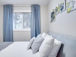 卡尔加里Gorgeous 2Br Condo w Parking Patio Coffee!的卧室配有带枕头的床铺和窗户。