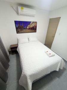 巴兰基亚CASA HOTEL YEMI的卧室配有白色的床铺和白色的毯子