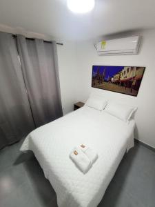 巴兰基亚CASA HOTEL YEMI的卧室配有白色的床铺和白色的毯子