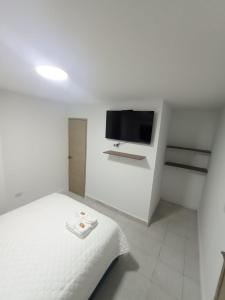 巴兰基亚CASA HOTEL YEMI的白色卧室配有床和平面电视