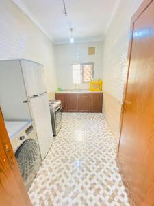 亚喀巴Galaxy Apartments的带冰箱的厨房和瓷砖地板。