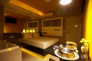 皮拉西卡巴Oasis Motel的卧室配有床和浴缸