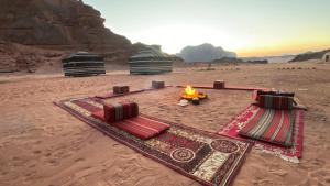 瓦迪拉姆Wadi rum Bedouin Experience的沙漠,沙子中有帐篷和火
