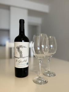 卢汉德库约Complejo Carrodilla - Lujan de Cuyo的两杯酒杯旁的一瓶葡萄酒