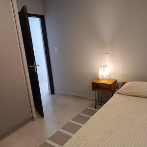 戈多伊克鲁斯Serenity的一间卧室配有一张床和一张带台灯的桌子