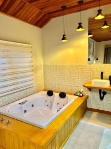 维奥康德马奥Verde da Mantiqueira Chalés的浴室设有大浴缸,配有两个灯