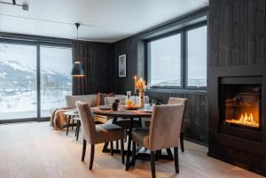 海姆瑟达尔Helt ny leilighet i Hemsedal, rett ved Fyri Resort - Ski inn - Ski out的一间带桌子和壁炉的用餐室