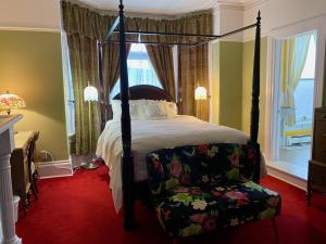 圣约翰斯玫瑰遗产旅馆的一间卧室配有四柱床和椅子