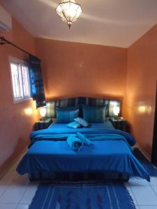 马拉喀什RIAD Anis的一间卧室配有蓝色的床和蓝色的毯子