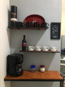 恰卡拉Casa Arbol de Paz habitación doble的一个带咖啡壶的架子和一瓶葡萄酒