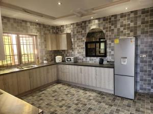 弗里敦Medi Square Lodge的厨房配有白色冰箱和瓷砖墙壁。