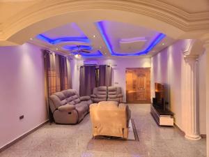 弗里敦Medi Square Lodge的带沙发和电视的客厅以及蓝色灯光
