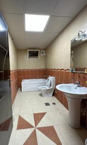 麦地那Al Asar almasi Suite Apartments的带浴缸、卫生间和盥洗盆的浴室