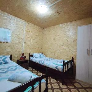乌尔齐尼Kucica Truma的一间卧室设有两张床和石墙